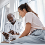 Image shows doctor showing information to patient on a tablet.