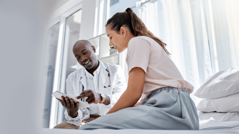 Image shows doctor showing information to patient on a tablet.