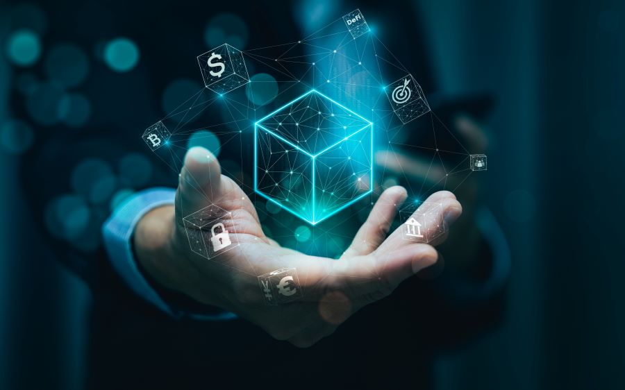 Hand from person in dark suit with white shirt presenting box of technology ideas on dark bokeh background