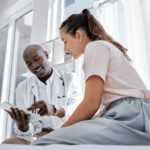 Image shows doctor showing information to patient on a tablet.