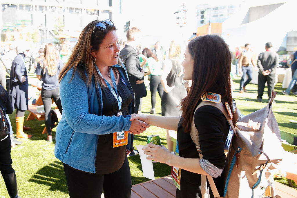 An image of Dreamforce, an annual event for small business owners, where two women meet and shake hands.